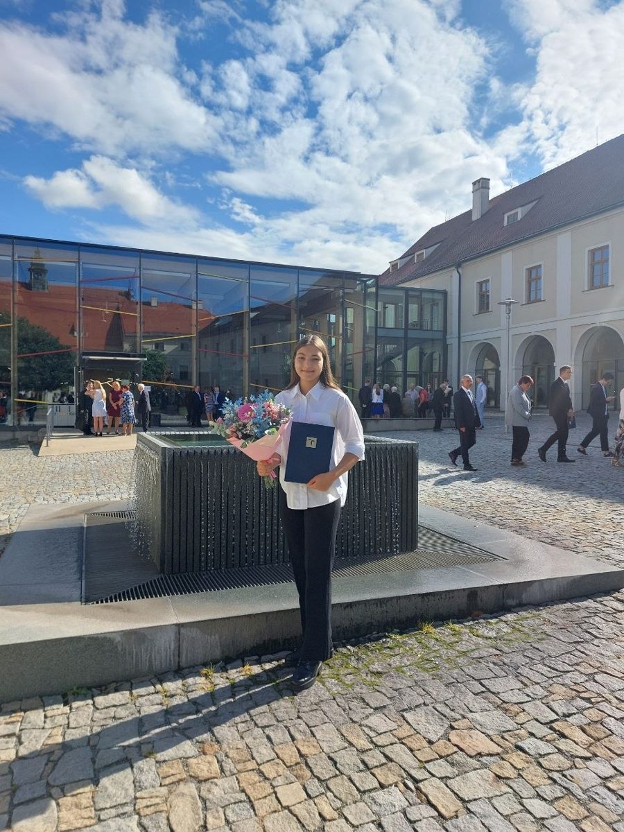 Sofiia with her Bachelor's diploma in the university garden